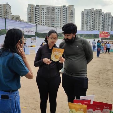 Three people standing outdoors with buildings in the background