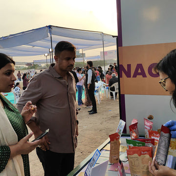 People interacting with a product display at an outdoor event.