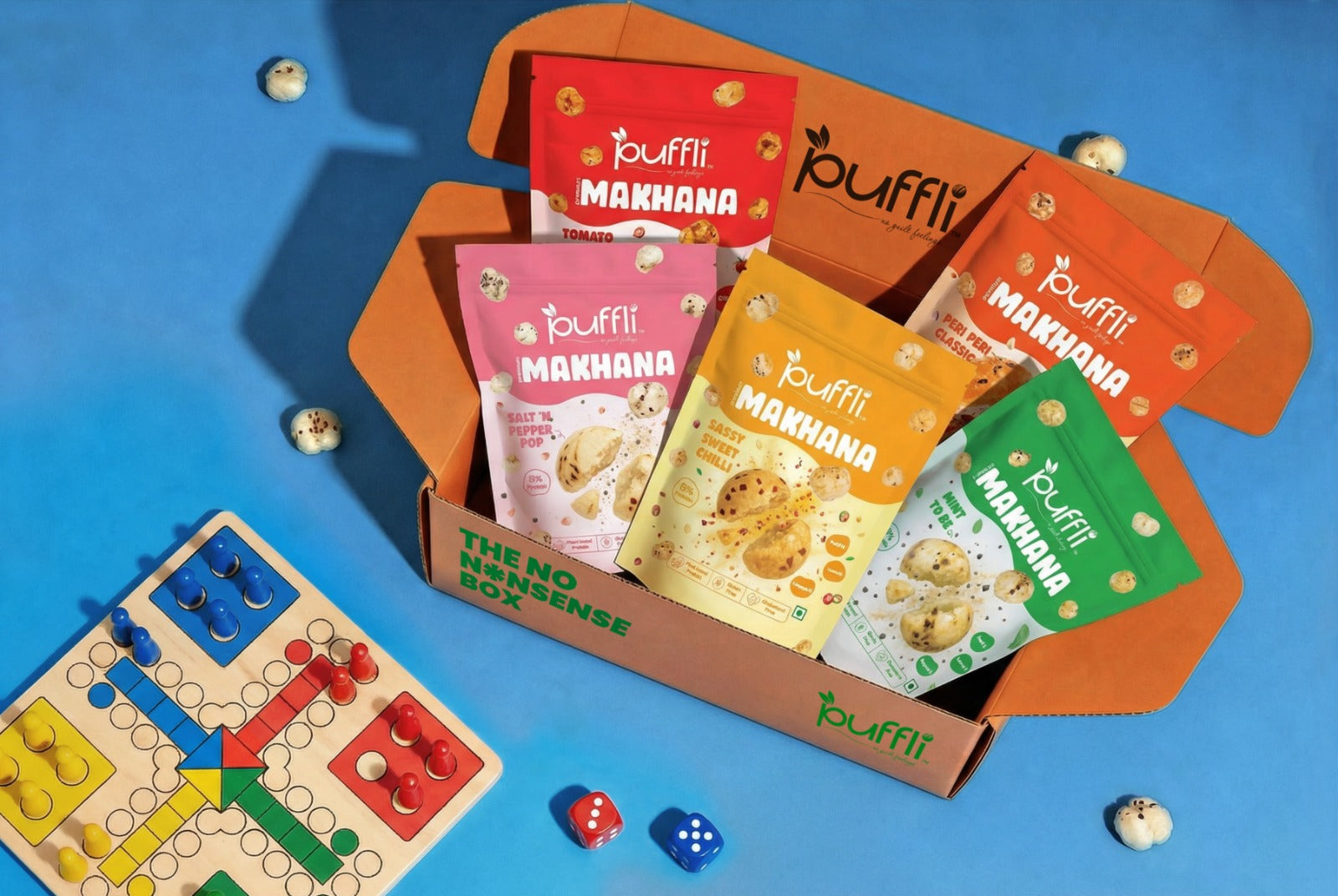 Puffli Makhana snack packs with a board game.