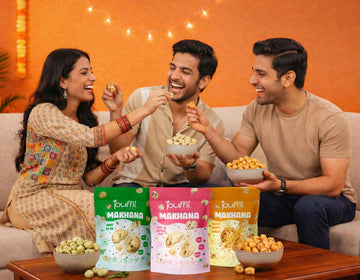 Three people enjoying snacks on a couch with puffli makhana